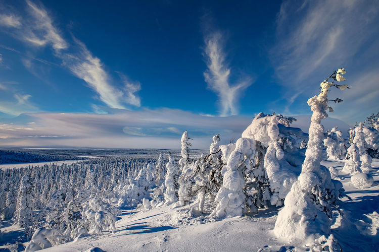 Panoramic view of snowcapped landscape against blue sky