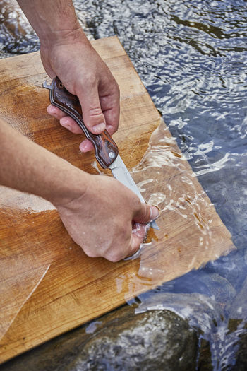 Hand washing knife in stream water