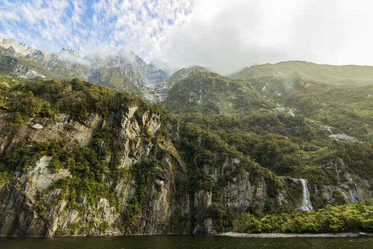 Low angle view of rocky mountains at milford sound