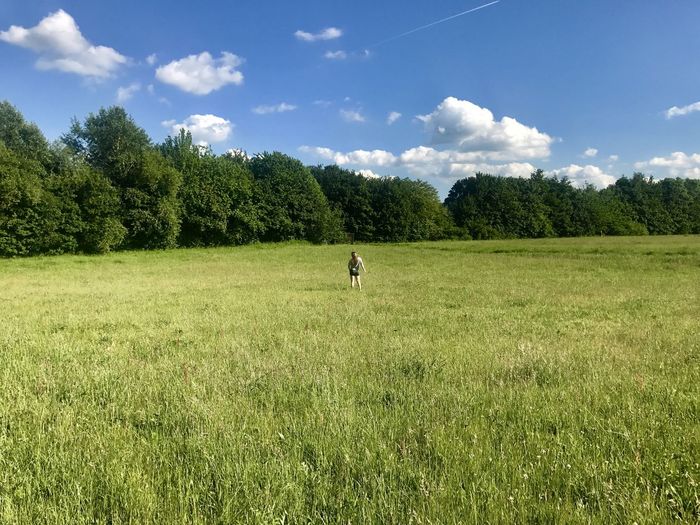 Man standing on grassy field against sky