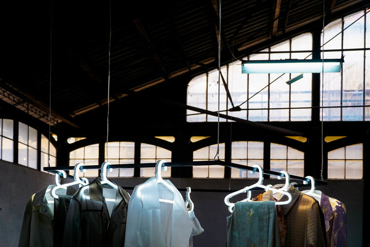 Interior of clothes hanging from ceiling in store