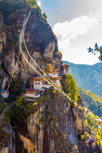 Buddhist temples on cliff against mountains with prayer flags