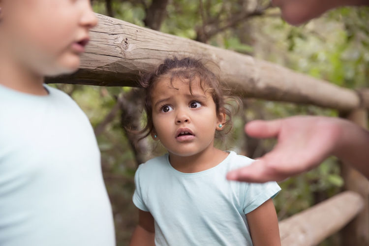 Cute girl looking at siblings