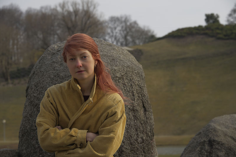 Portrait of young woman standing on rock