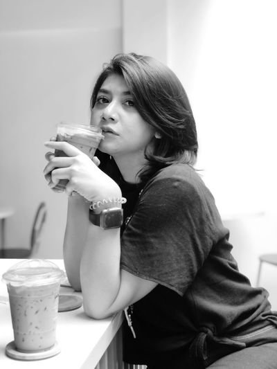 Side view of young woman drinking coffee