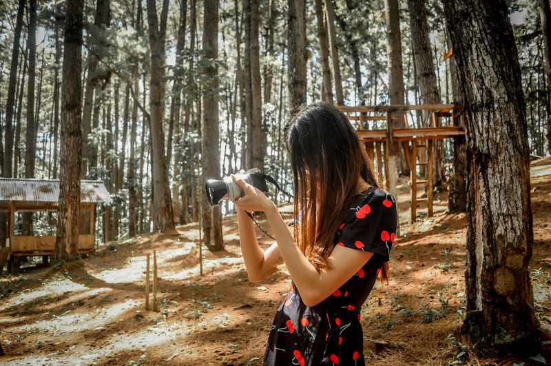 Young woman using mobile phone in forest