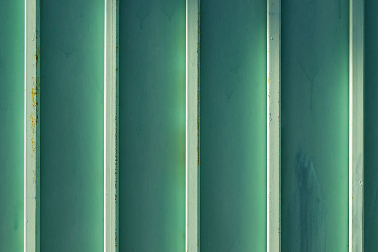 Green and blue metal fence background, close-up