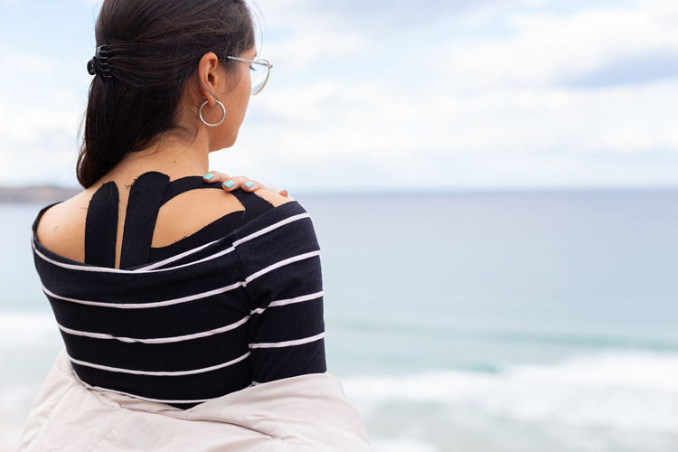Rear view of woman looking at sea against sky