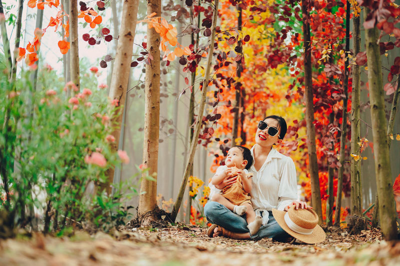 People sitting by plants during autumn
