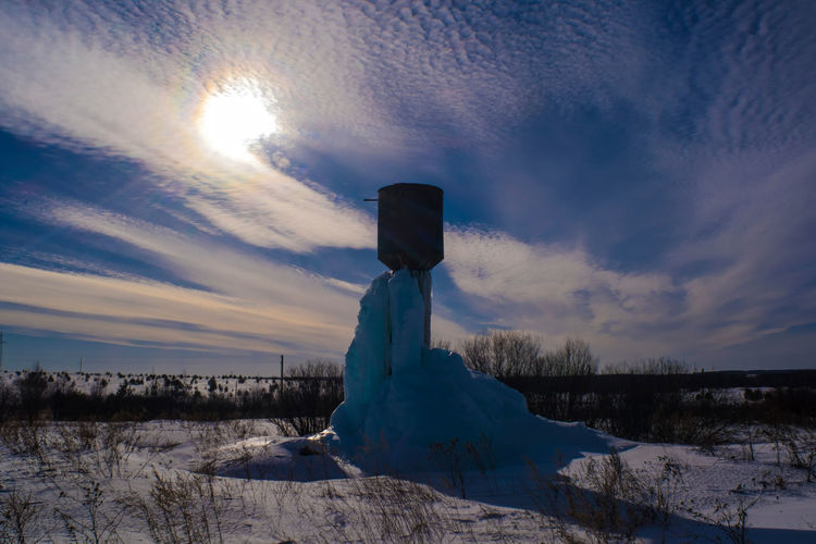 Scenic view of snow covered field against sky during sunset