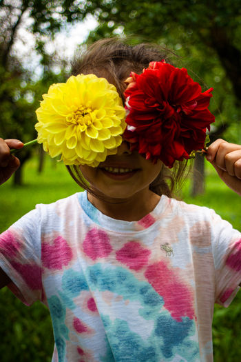 Low angle view of child holding flowering plant