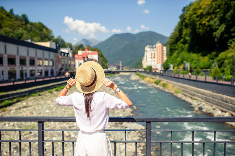 Rear view of woman standing by railroad tracks