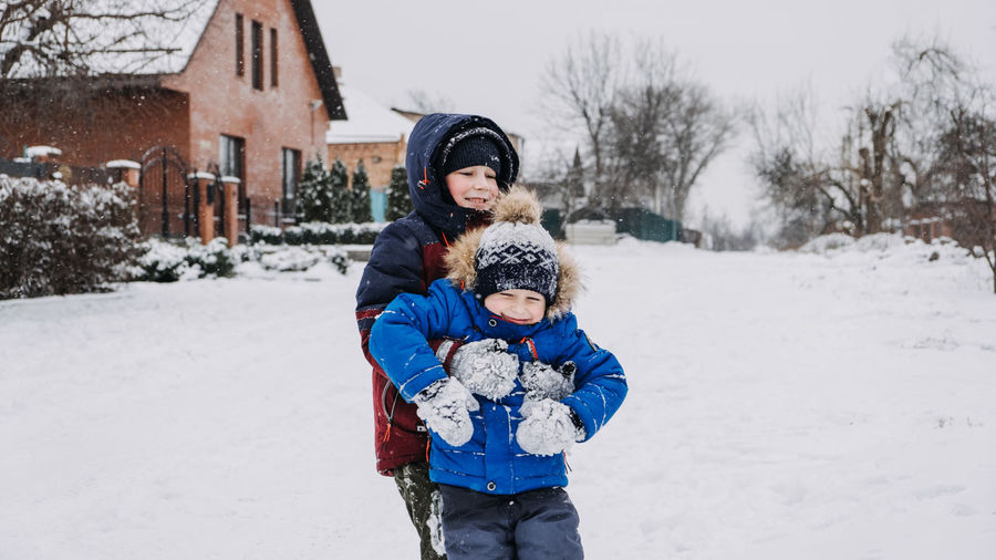 Outdoor winter activities for kids. kids playing in the suburbs, winter backyard gathering. boys