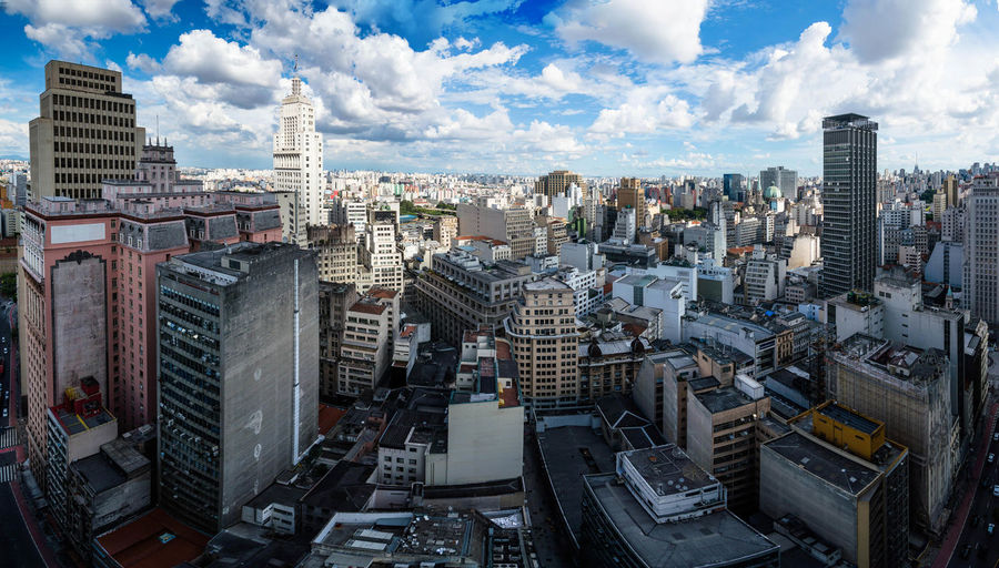 Aerial view of cityscape against cloudy sky