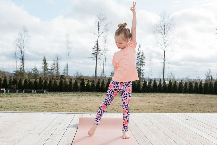 Young girl stretching doing yoga in her back yard at home