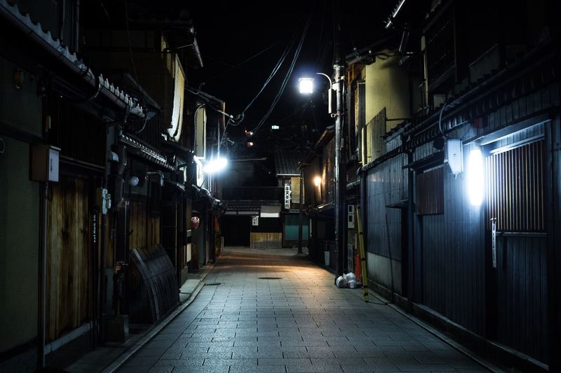 Illuminated street amidst buildings at night