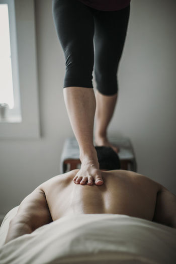 Massage therapist uses ashiatsu technique to work on patient's back