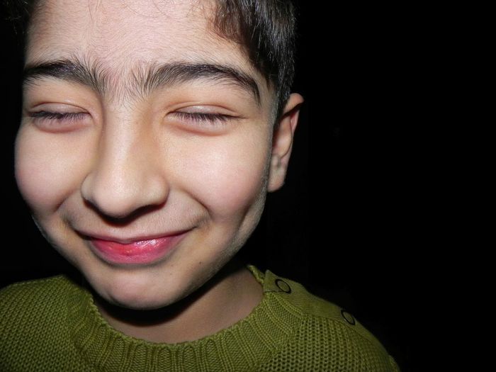 Close-up of boy with eyes closed at night