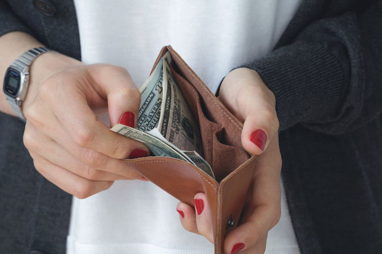 Midsection of woman holding wallet