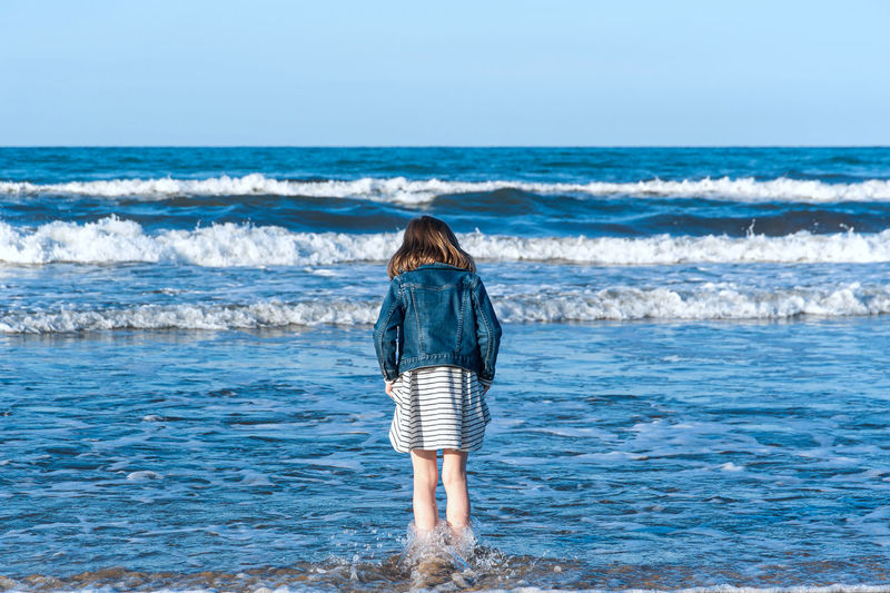Rear view of girl standing on beach