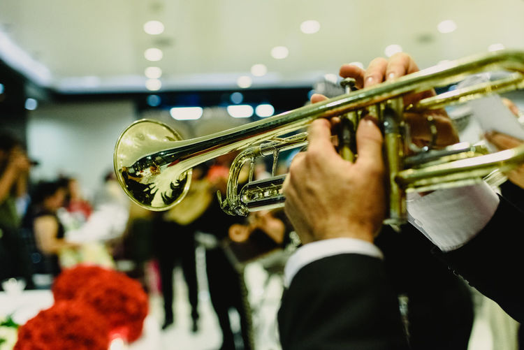Cropped hands of man playing trumpet during celebration