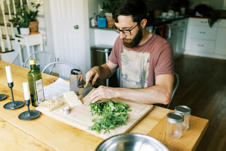 Young man preparing food on table at home