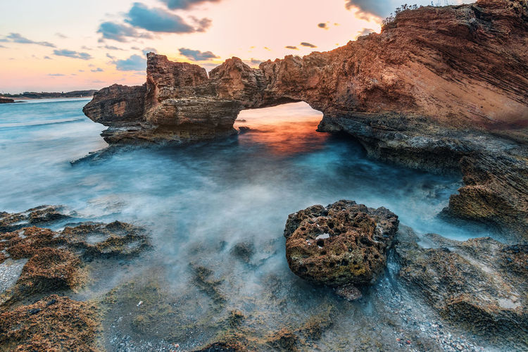 Scenic view of rocks in sea during sunset