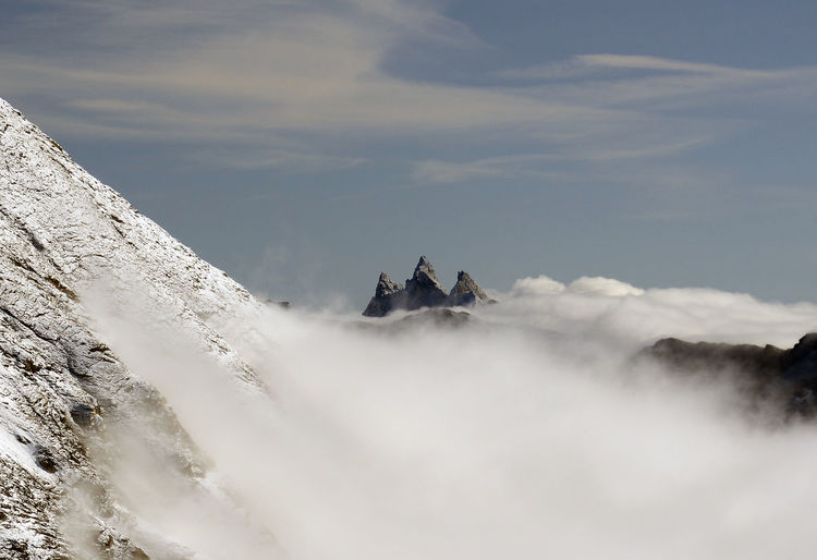 Low angle view of people on mountain against sky