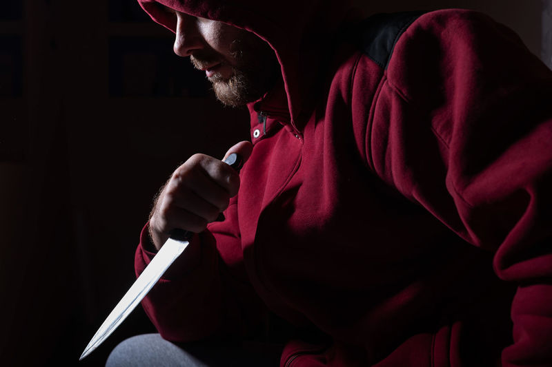 Man holding knife against black background