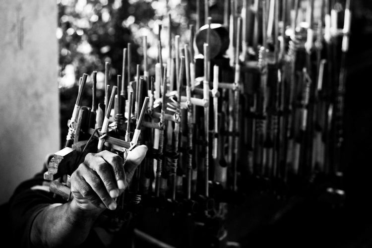 Cropped image of hand playing angklung