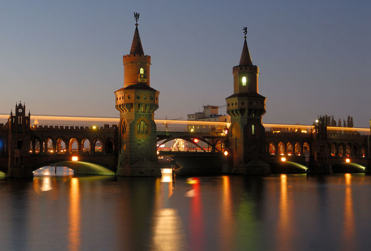 Illuminated oberbaum bridge over river at night