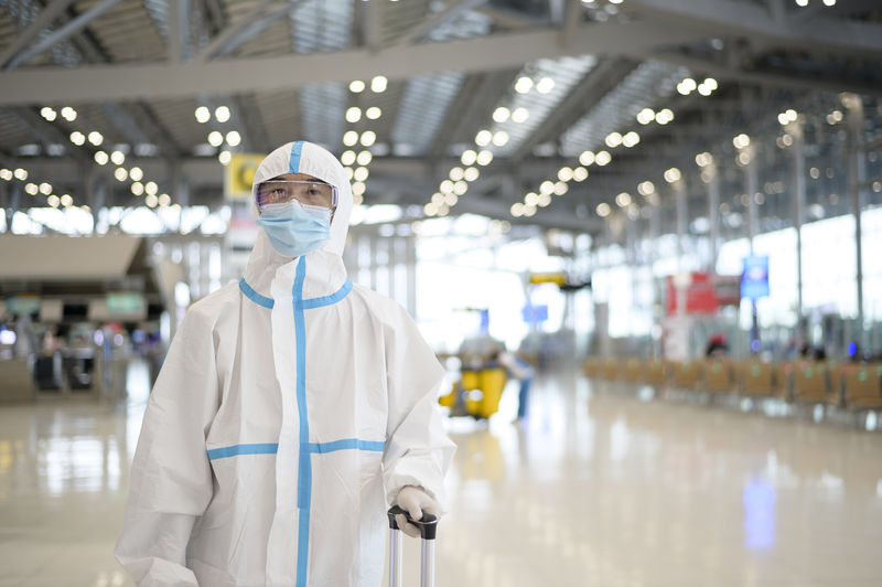 Portrait of man wearing protective suit standing at airport