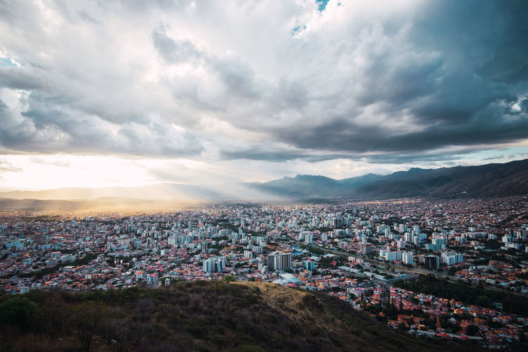 Areal view of cochabamba, bolivia with a cloudy sky and rays of sunlight. located in south america