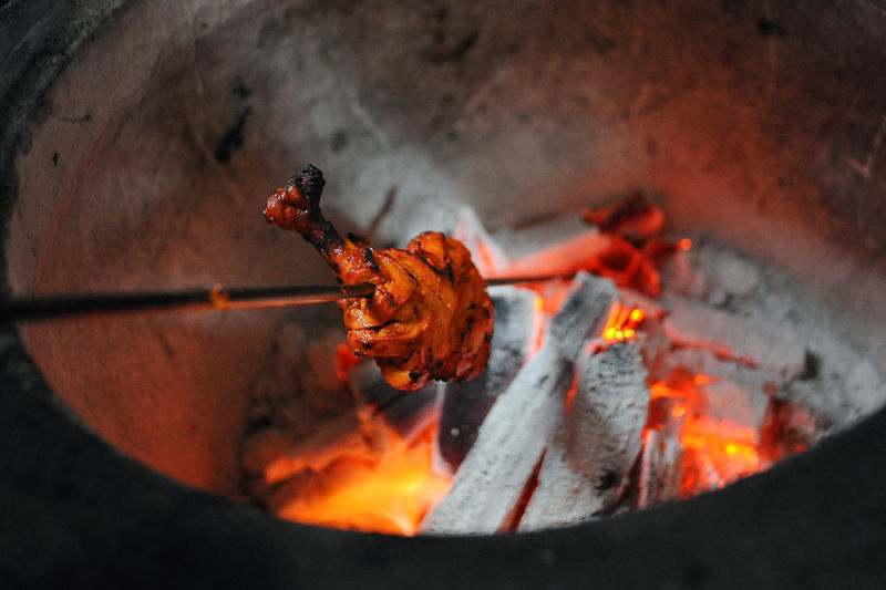 Close-up of chicken cooking in tandoor