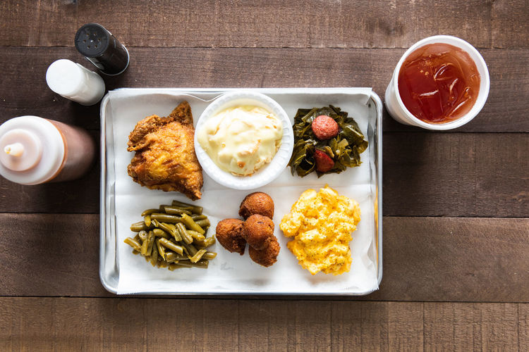 A tray of fried chicken, green beans, mac & cheese meal with sweet tea