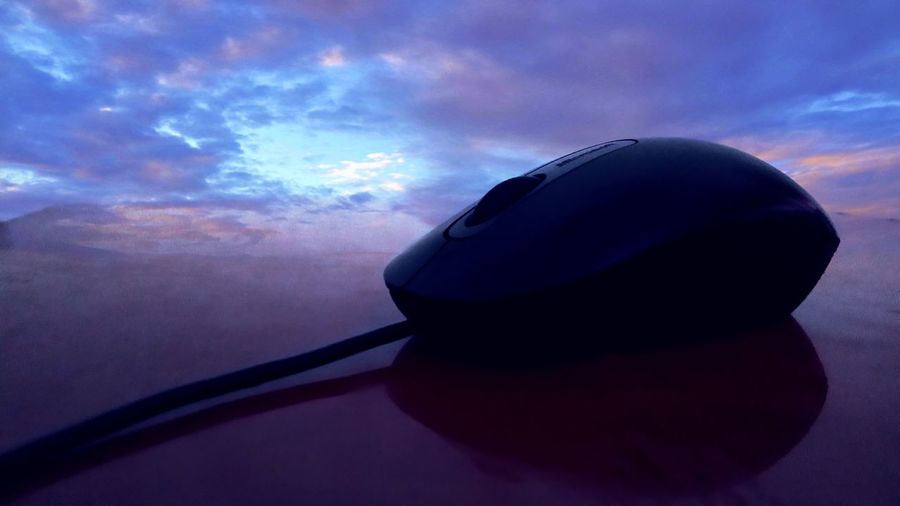 Close-up of computer mouse against sky