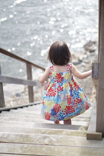 Rear view of young girl on beach steps