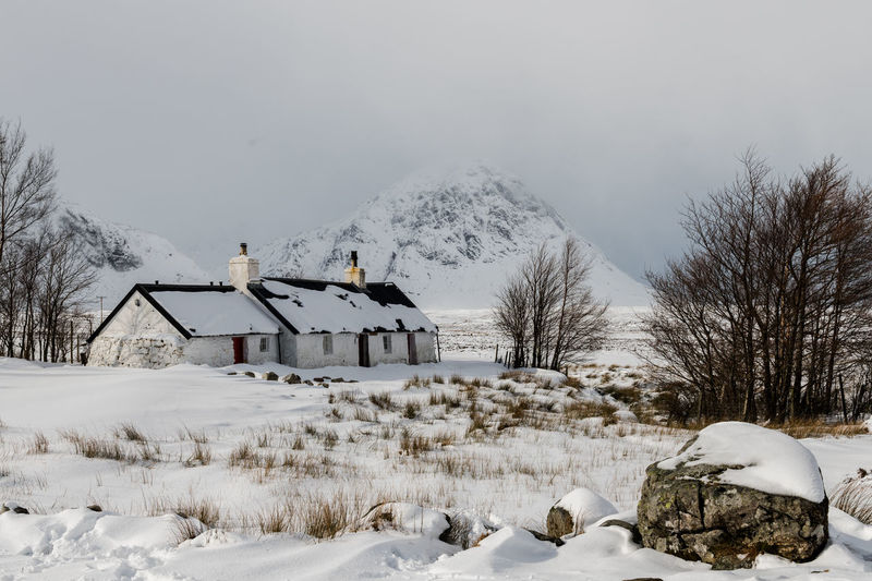 Scottish highland winter landscape featuring a traditional cottage 