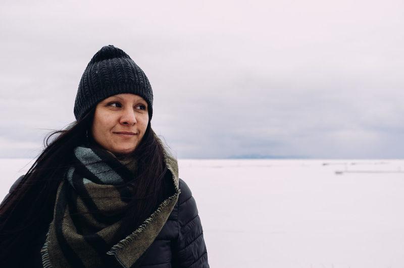 Portrait of senior woman against sky during winter