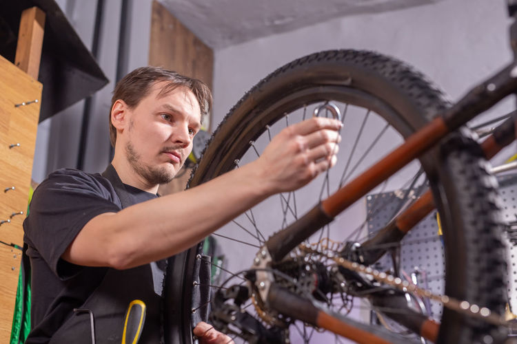 Low angle view of worker repairing bicycle