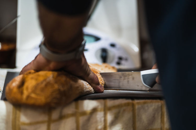 Man working cutting bread on table at kitchen