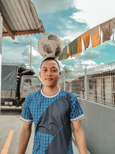 Portrait of boy standing against sky