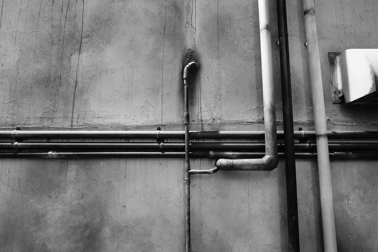 Low angle view of pipelines on wall