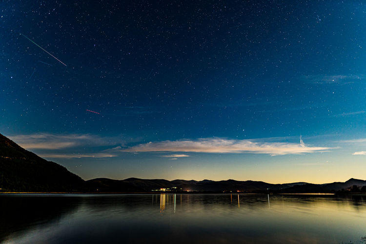 Bassenthwaite lake on a moonlit night with a meteor in the sky from the perseids meteor shower