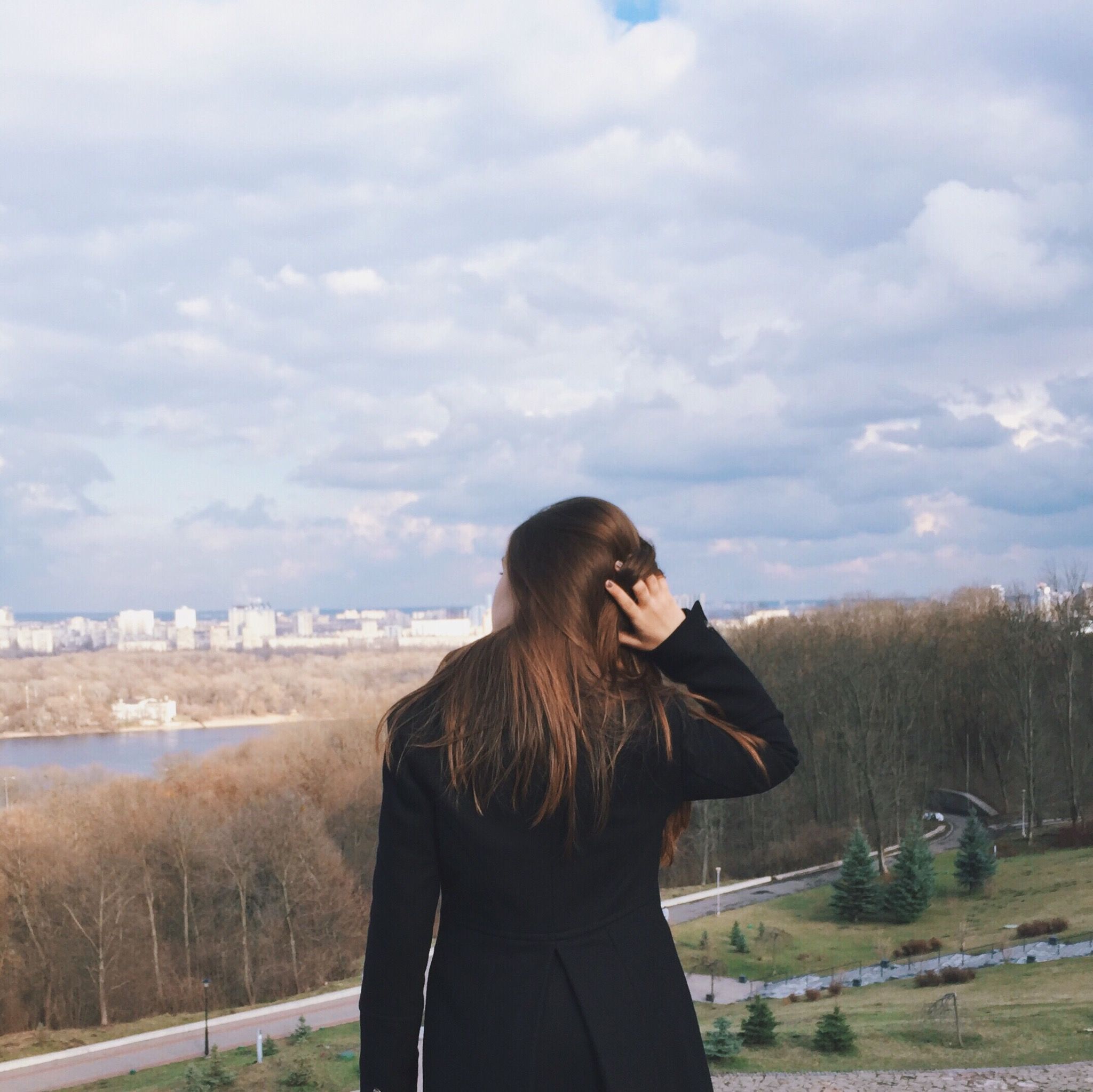lifestyles, sky, young adult, waist up, leisure activity, standing, casual clothing, long hair, rear view, young women, field, three quarter length, person, brown hair, cloud - sky, landscape, focus on foreground, nature