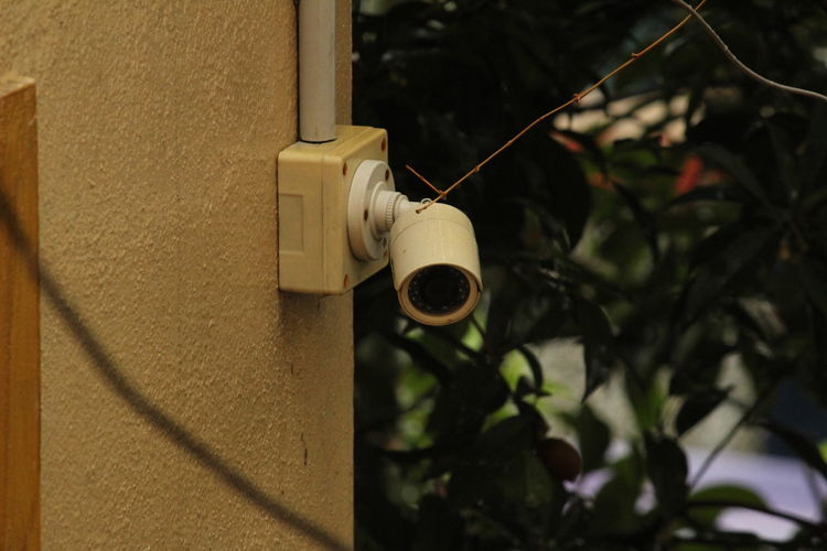 Old and simple cctv camera in the wall on outside of the house in working condition. 