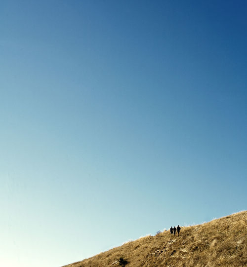 Low angle view of land against clear blue sky