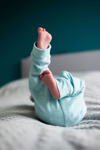 Low section of baby on bed