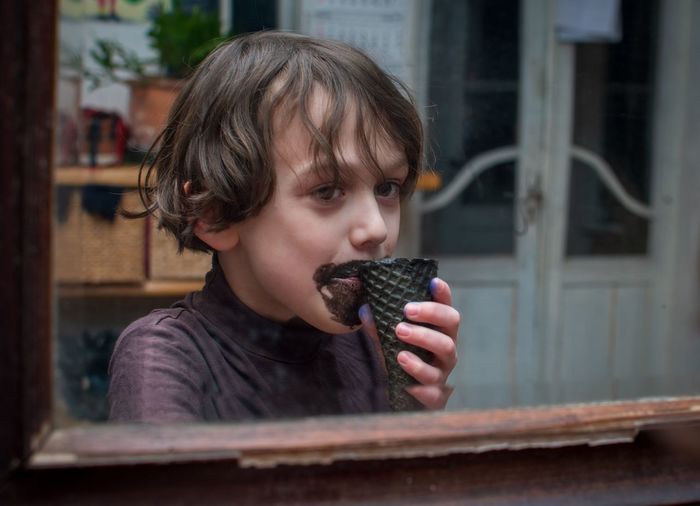 Portrait of cute boy holding black ice cream