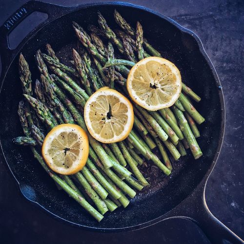 High angle view of asparagus with lemon slice in bowl